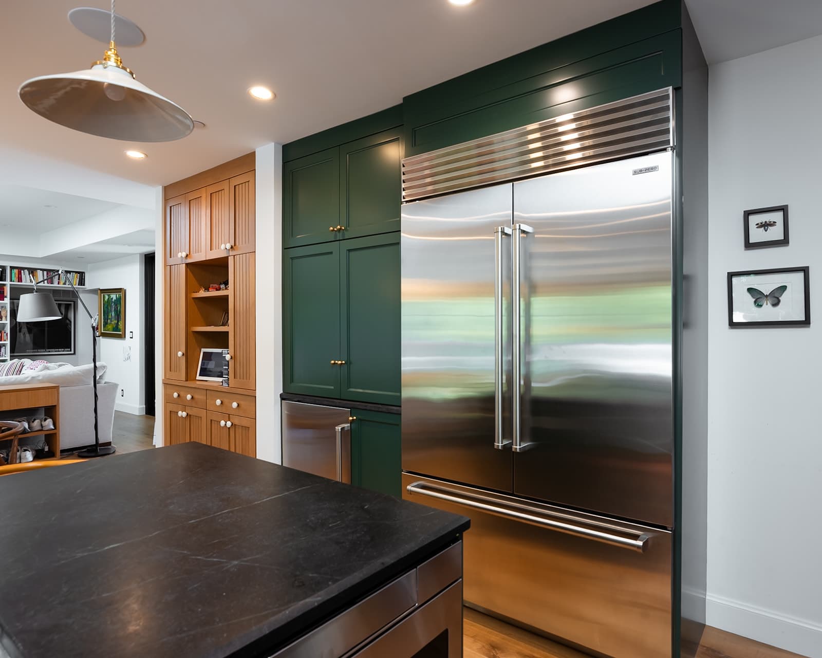 Green kitchen cabinetry flanking a full-height Sub-Zero refrigerator